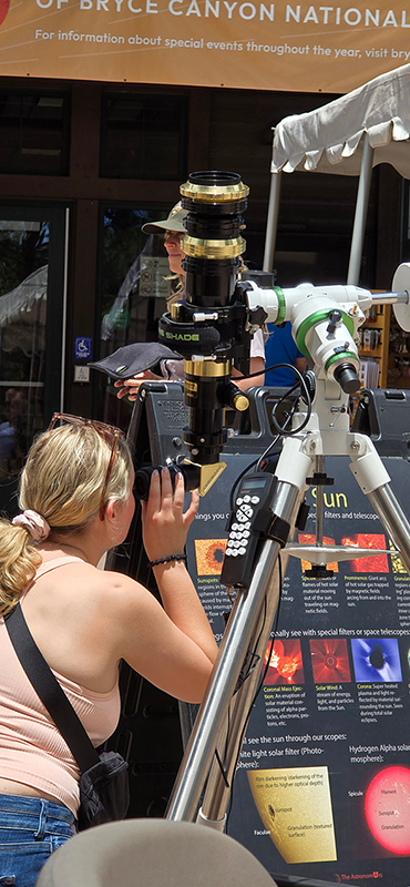 Bryce Canyon Astronomy Festival visitors observe the sun through a telescope with a filter