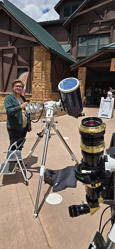 Bryce Canyon Astronomy Festival visitors observe the sun through a telescope with a filter. Samuel Black is providing support in this image.