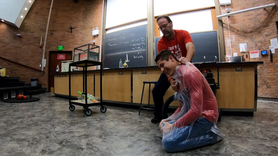 Beehler demonstrates atmospheric pressure by putting a student in a bag and evacuating the air.